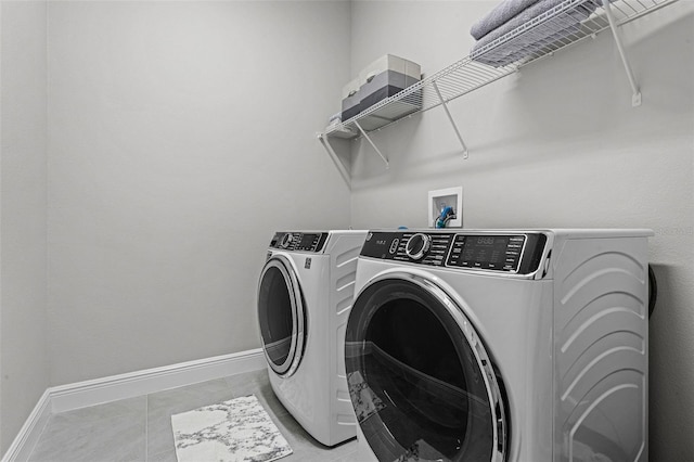 washroom with light tile patterned floors, baseboards, laundry area, and independent washer and dryer
