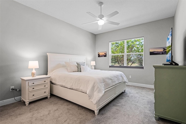 bedroom with light colored carpet, baseboards, and a ceiling fan