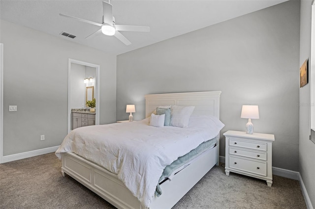 carpeted bedroom with ensuite bath, ceiling fan, baseboards, and visible vents