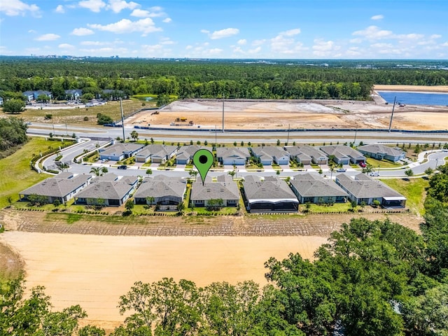 drone / aerial view with a forest view, a water view, and a residential view