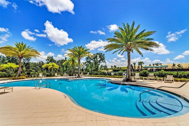 pool featuring fence and a patio