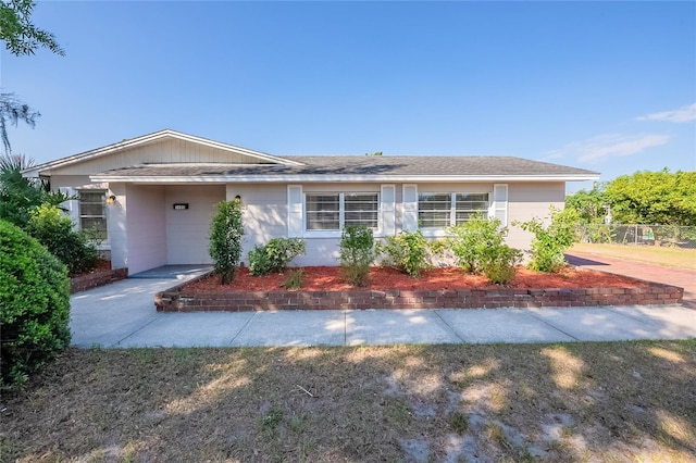 ranch-style home with concrete block siding and fence