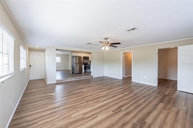 unfurnished living room with visible vents, wood finished floors, baseboards, and a ceiling fan
