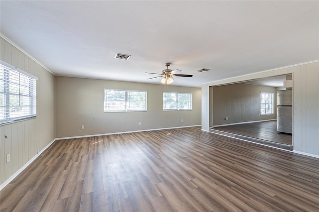 unfurnished living room featuring baseboards, wood finished floors, visible vents, and ceiling fan