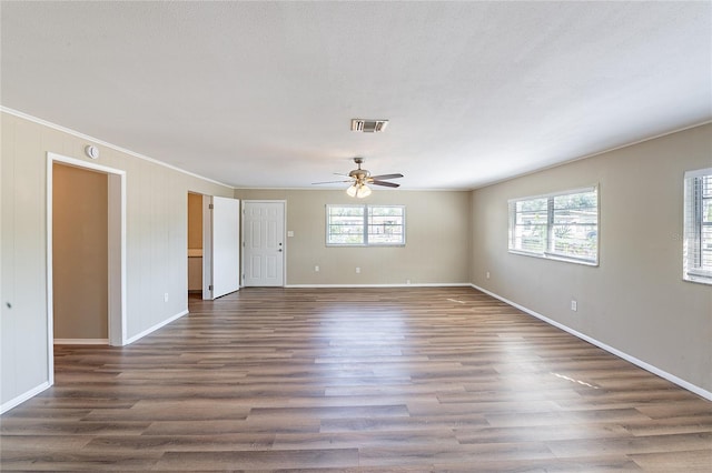 empty room featuring baseboards, a ceiling fan, wood finished floors, and visible vents