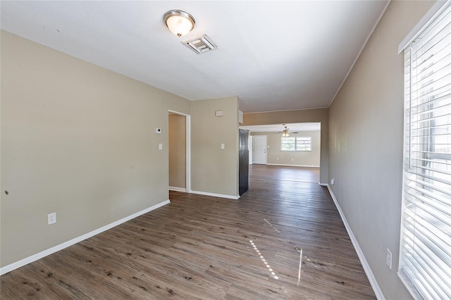 unfurnished room with baseboards, wood finished floors, visible vents, and a ceiling fan