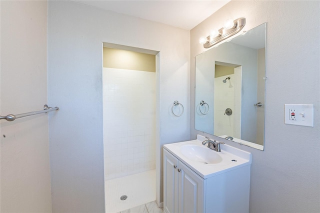 full bathroom featuring vanity and a tile shower