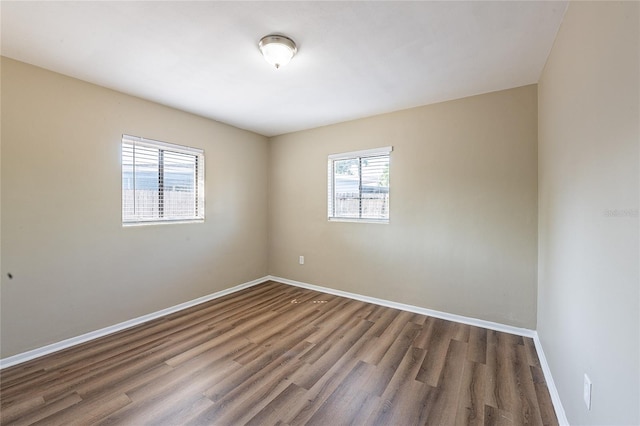 empty room featuring baseboards and wood finished floors