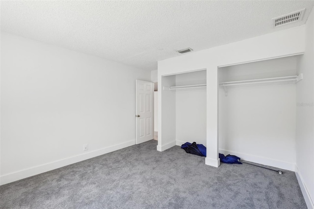 11352 Persimmon Blvd, West Palm Beach, FL 33411 - unfurnished bedroom featuring two closets, carpet floors, a textured ceiling, and baseboards