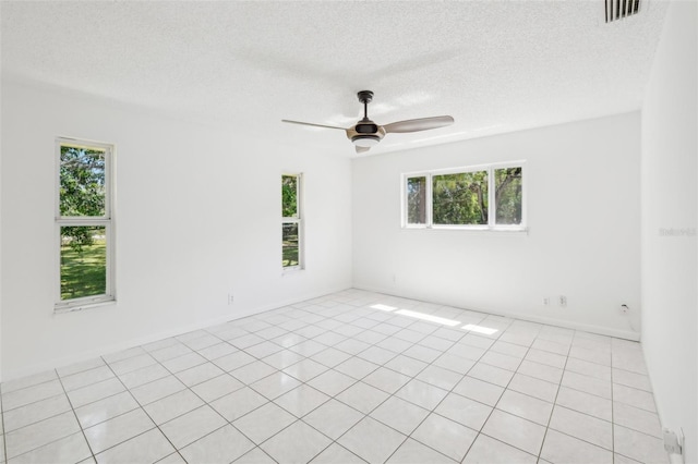 11352 Persimmon Blvd, West Palm Beach, FL 33411 - empty room with plenty of natural light, a textured ceiling, ceiling fan, and light tile patterned flooring