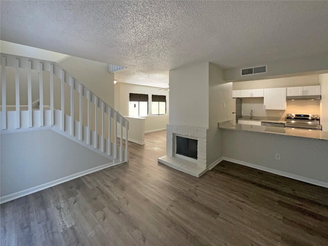 5126 Picadilly Circus Ct Unit 11, Orlando, FL 32839 - unfurnished living room with dark wood-type flooring, a textured ceiling, visible vents, and stairway