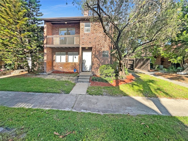 5126 Picadilly Circus Ct Unit 11, Orlando, FL 32839 - view of front facade with brick siding, a balcony, fence, and a front lawn