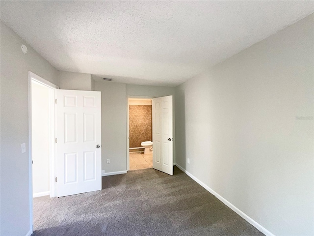 5126 Picadilly Circus Ct Unit 11, Orlando, FL 32839 - unfurnished bedroom with baseboards, dark colored carpet, connected bathroom, and a textured ceiling