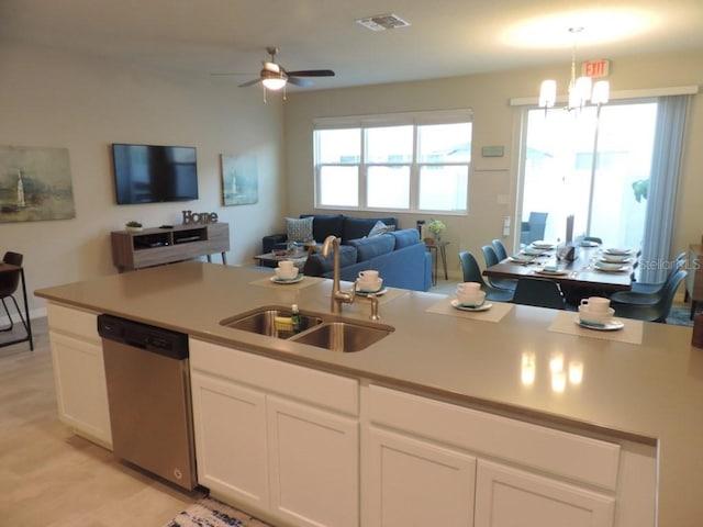kitchen with visible vents, white cabinets, dishwasher, a sink, and open floor plan