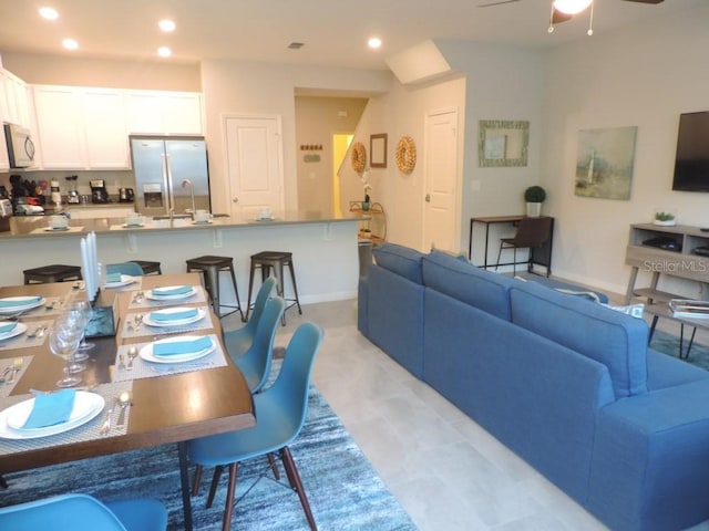 living room featuring baseboards, a ceiling fan, and recessed lighting