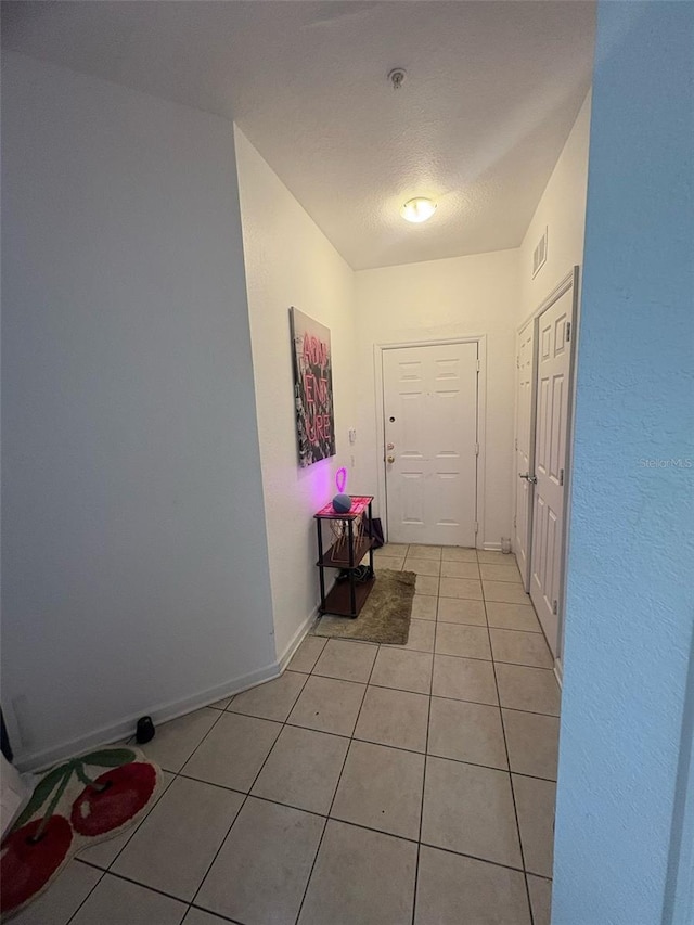 interior space with light tile patterned floors, visible vents, and baseboards