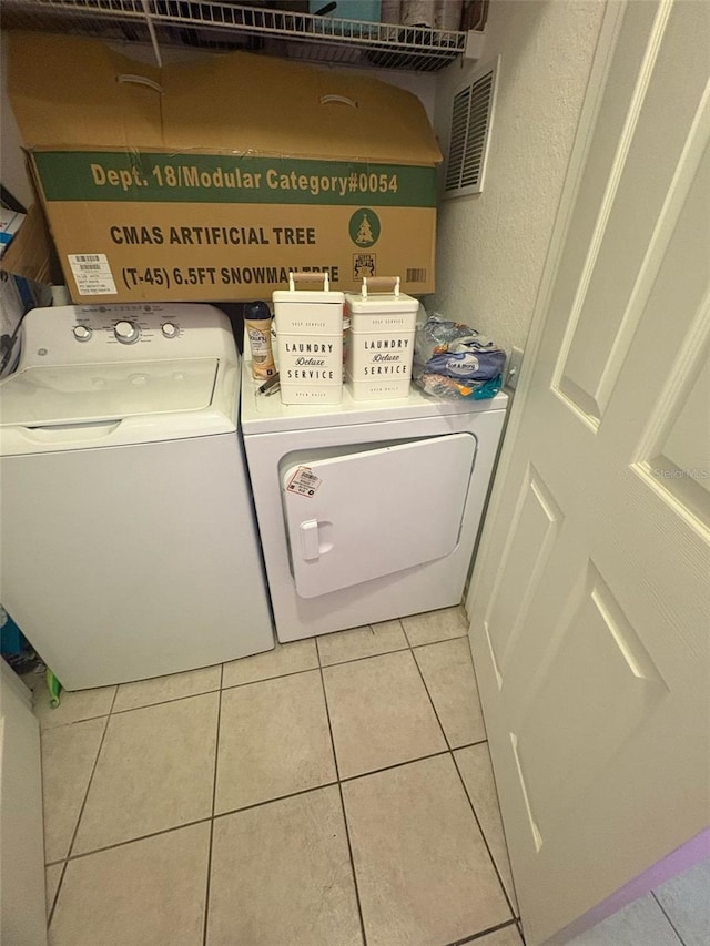 laundry area featuring independent washer and dryer, laundry area, and light tile patterned flooring