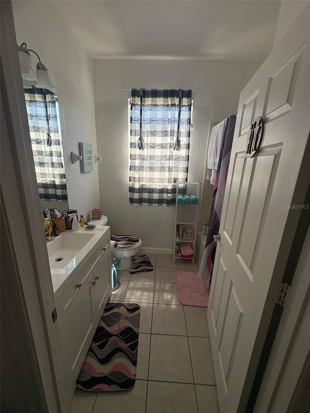 bathroom with toilet, tile patterned floors, and vanity