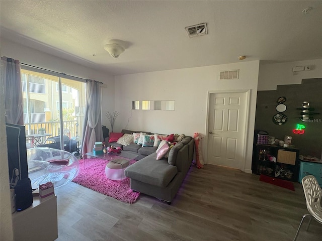living area with visible vents and wood finished floors