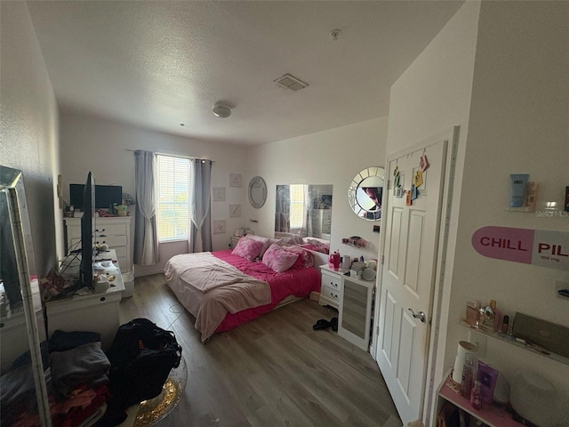 bedroom featuring light wood finished floors and visible vents