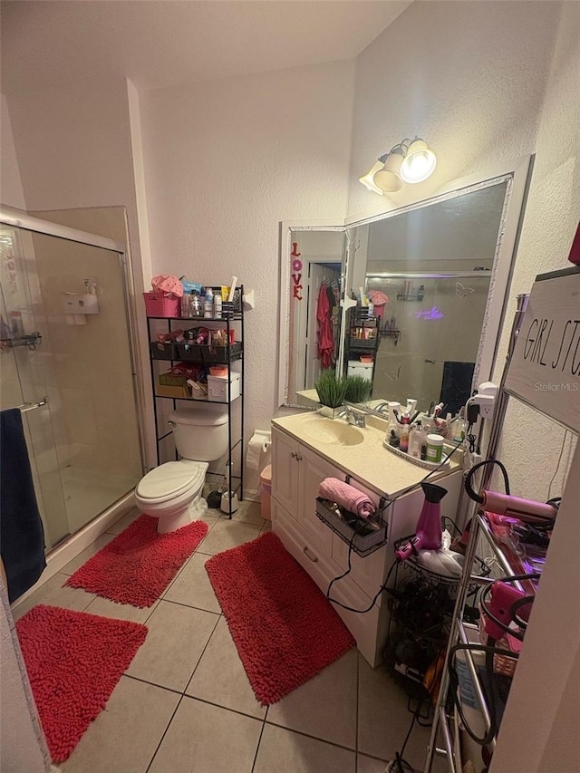 bathroom featuring tile patterned floors, a shower stall, vanity, and a textured wall