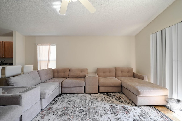 living room with a textured ceiling and ceiling fan