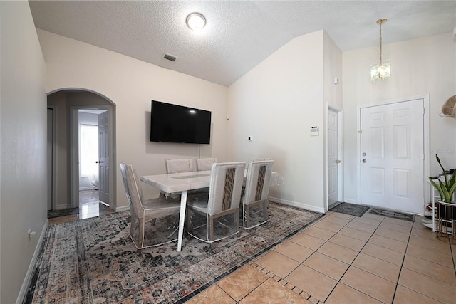 dining room with visible vents, baseboards, arched walkways, a chandelier, and light tile patterned flooring