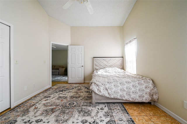 bedroom featuring a textured ceiling, ceiling fan, and baseboards