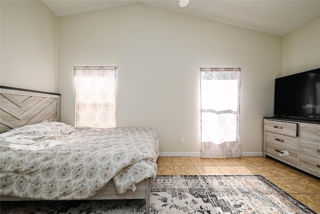 bedroom featuring baseboards, vaulted ceiling, and light tile patterned flooring