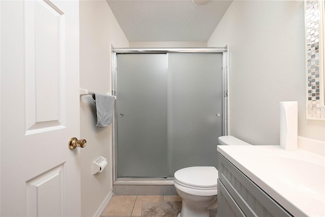 full bathroom with a textured ceiling, vanity, toilet, a stall shower, and tile patterned floors