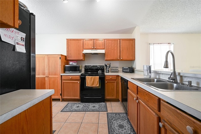 kitchen featuring a sink, brown cabinetry, black appliances, and under cabinet range hood