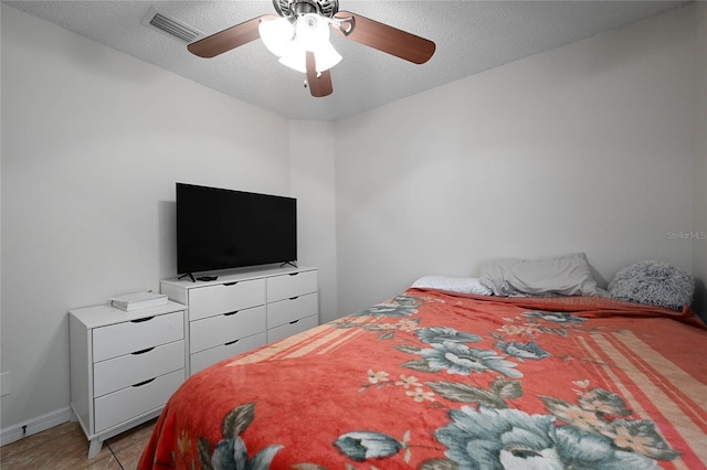 bedroom with visible vents, a ceiling fan, and a textured ceiling