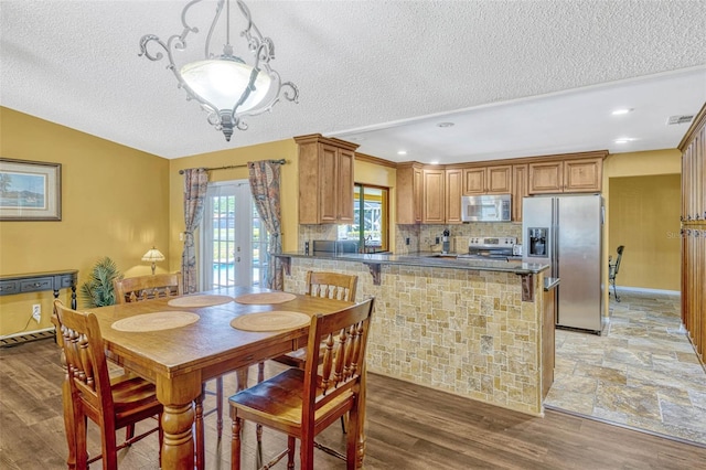7655 Persian Ct, Orlando, FL 32819 - dining space featuring vaulted ceiling, light wood-type flooring, a textured ceiling, and visible vents