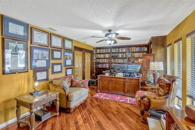 7655 Persian Ct, Orlando, FL 32819 - living area featuring wood finished floors, a ceiling fan, visible vents, and a textured ceiling