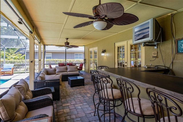 7655 Persian Ct, Orlando, FL 32819 - view of patio / terrace with french doors, a lanai, outdoor dry bar, ceiling fan, and an outdoor living space