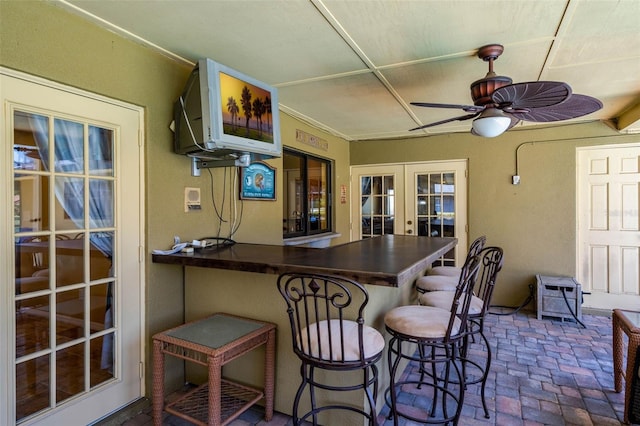 7655 Persian Ct, Orlando, FL 32819 - bar featuring brick floor, a ceiling fan, and french doors