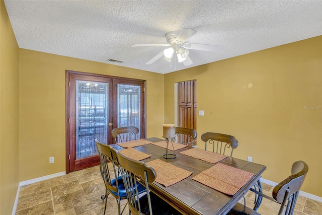7655 Persian Ct, Orlando, FL 32819 - dining room featuring visible vents, a ceiling fan, stone tile flooring, baseboards, and a textured ceiling
