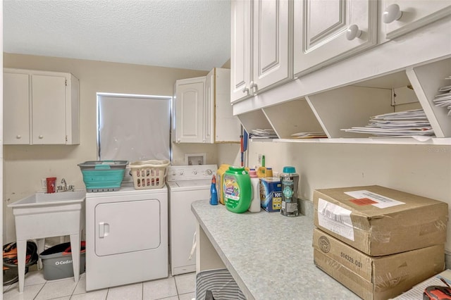 7655 Persian Ct, Orlando, FL 32819 - laundry room featuring washing machine and clothes dryer, light tile patterned flooring, a textured ceiling, and cabinet space