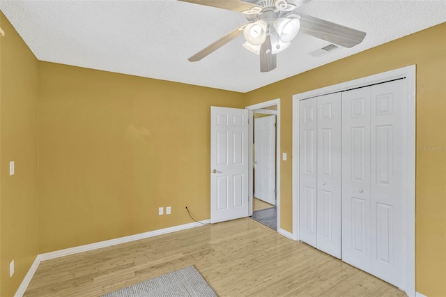 7655 Persian Ct, Orlando, FL 32819 - unfurnished bedroom featuring light wood finished floors, a textured ceiling, baseboards, visible vents, and a closet