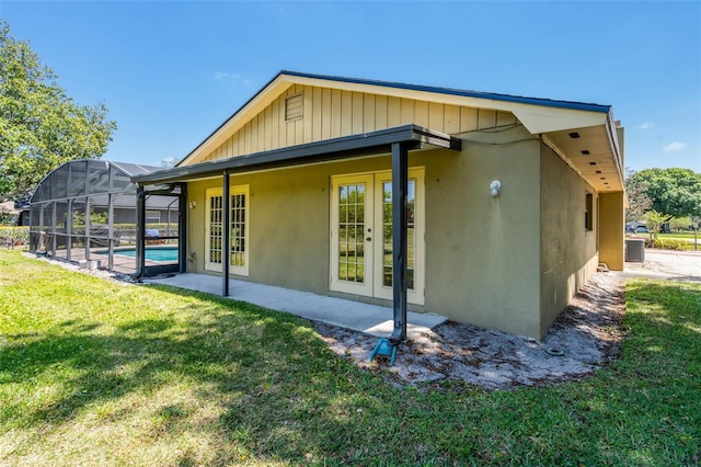 7655 Persian Ct, Orlando, FL 32819 - rear view of house with central AC, stucco siding, a patio area, french doors, and a lawn