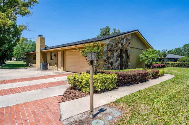 7655 Persian Ct, Orlando, FL 32819 - view of front of house with stone siding, a chimney, concrete driveway, a garage, and a front yard