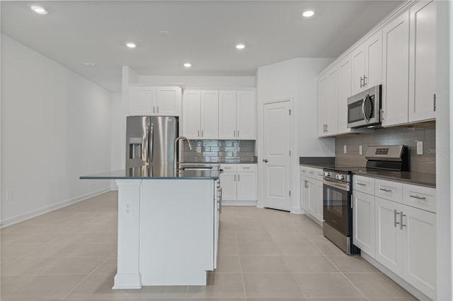 1908 Blissful Dr, Kissimmee, FL 34744 - kitchen featuring backsplash, dark countertops, a center island with sink, stainless steel appliances, and a sink