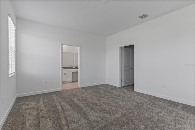 1908 Blissful Dr, Kissimmee, FL 34744 - unfurnished bedroom featuring carpet flooring, visible vents, baseboards, and connected bathroom