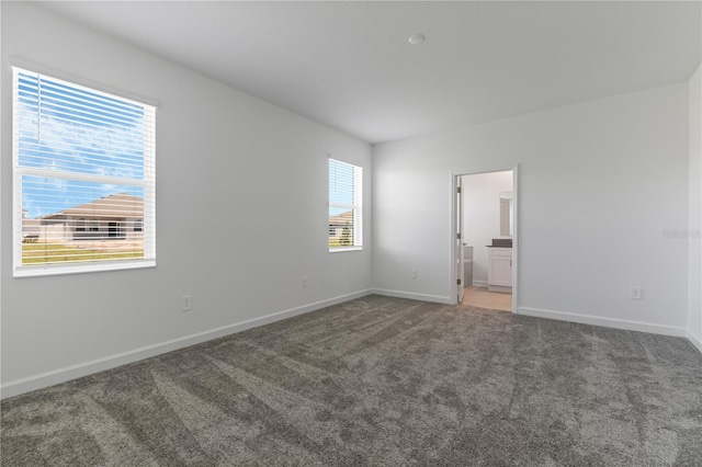 1908 Blissful Dr, Kissimmee, FL 34744 - unfurnished bedroom with baseboards, connected bathroom, and carpet floors