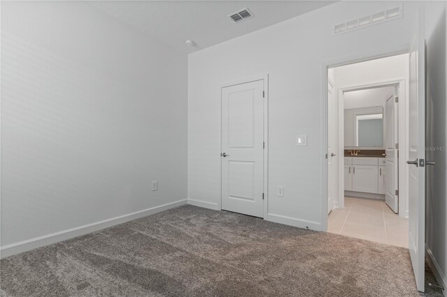 1908 Blissful Dr, Kissimmee, FL 34744 - unfurnished bedroom featuring visible vents, baseboards, light carpet, and light tile patterned floors