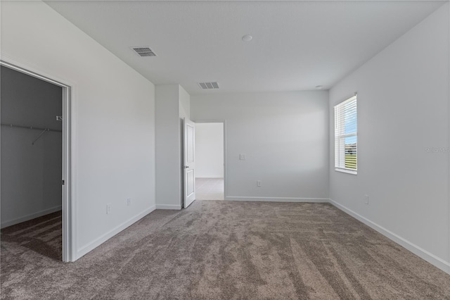 1908 Blissful Dr, Kissimmee, FL 34744 - unfurnished bedroom featuring visible vents, baseboards, a walk in closet, and carpet flooring