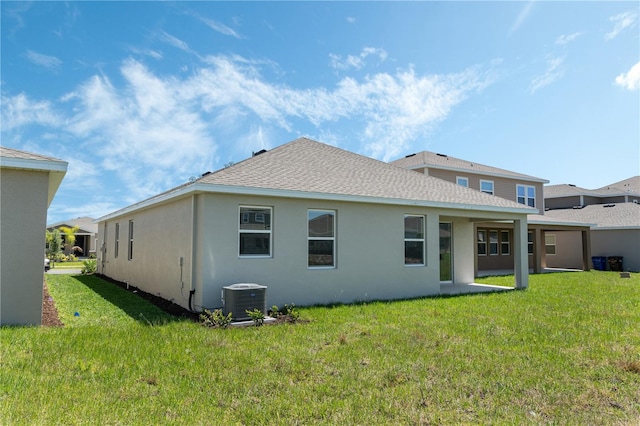 1908 Blissful Dr, Kissimmee, FL 34744 - rear view of property featuring central AC unit, a shingled roof, a lawn, and stucco siding