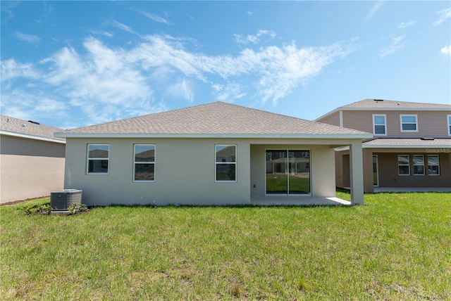 1908 Blissful Dr, Kissimmee, FL 34744 - back of house featuring central AC, a shingled roof, a lawn, and stucco siding