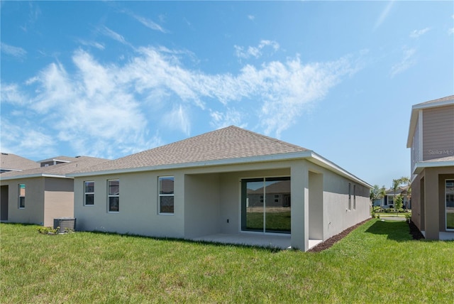 1908 Blissful Dr, Kissimmee, FL 34744 - rear view of house featuring a patio, a yard, a shingled roof, and stucco siding