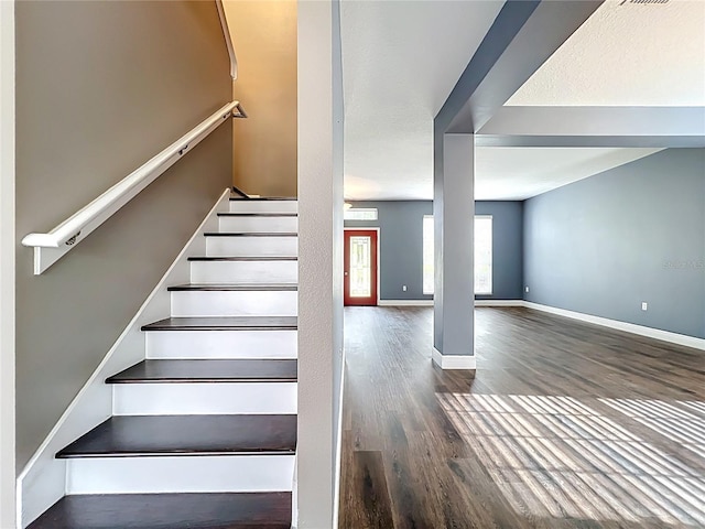 stairway with wood finished floors and baseboards